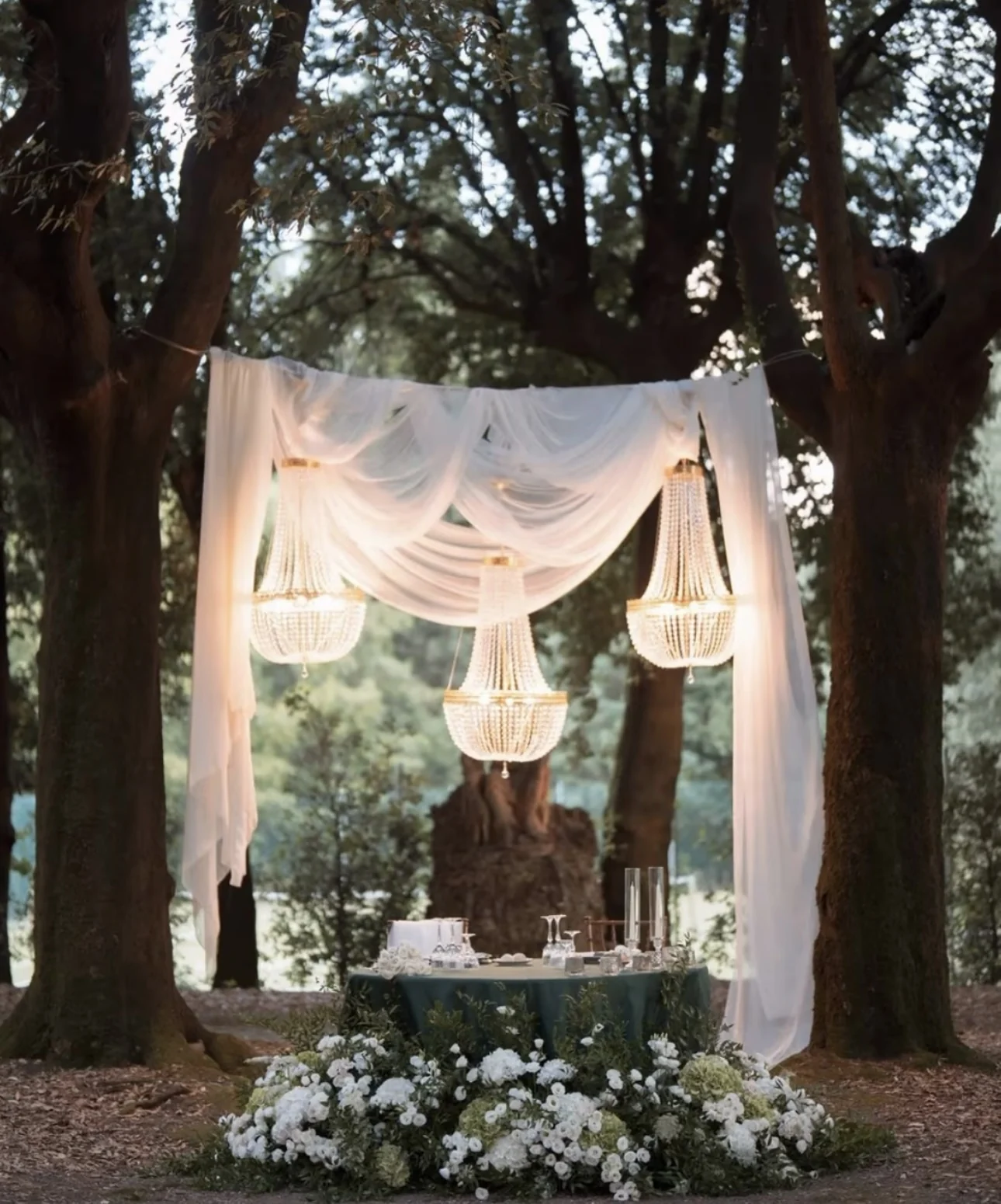 Struttura con drappeggi bianchi e lampadari nel giardino