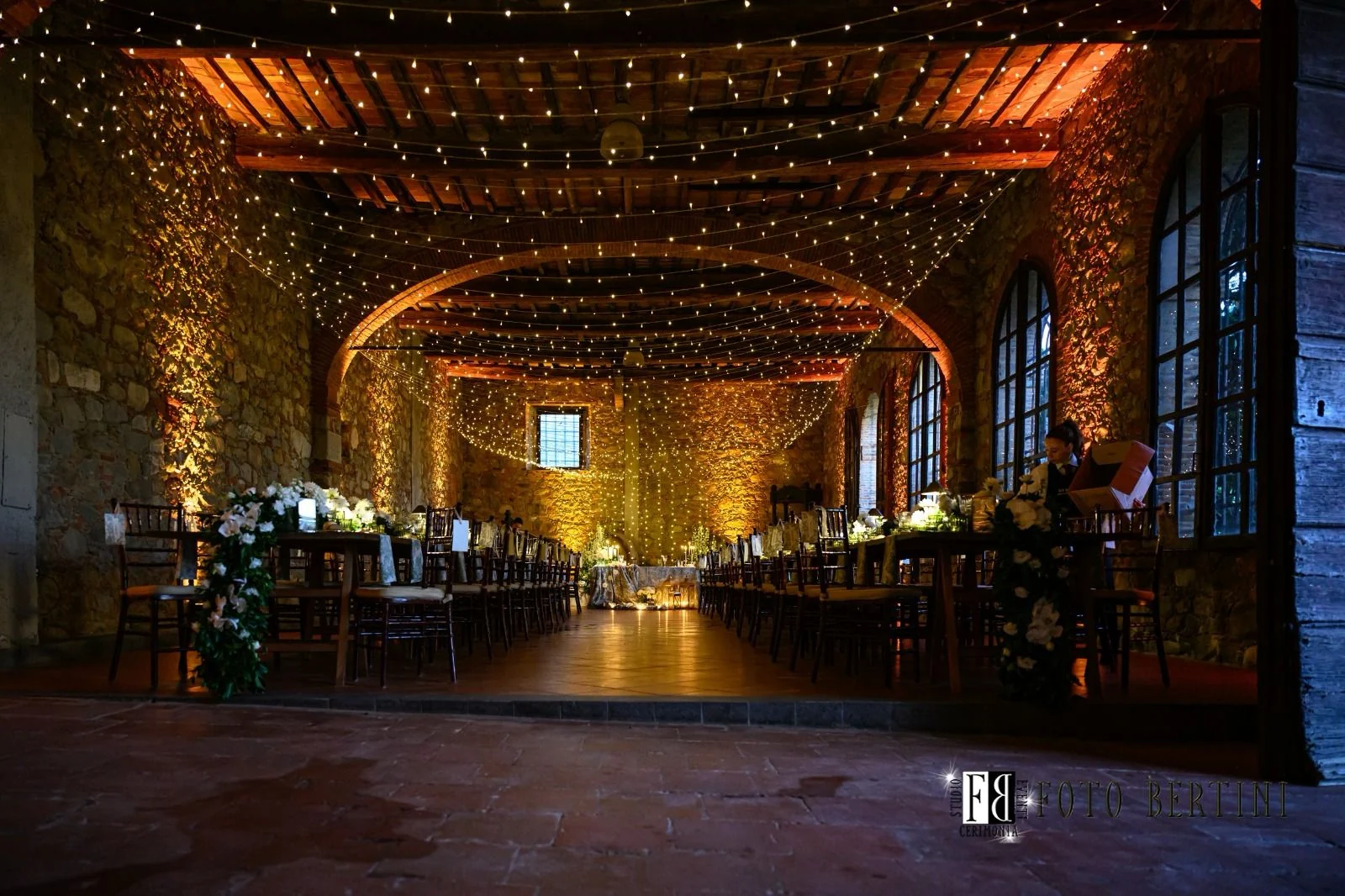Sala storica illuminata con luci calde e fili luminosi