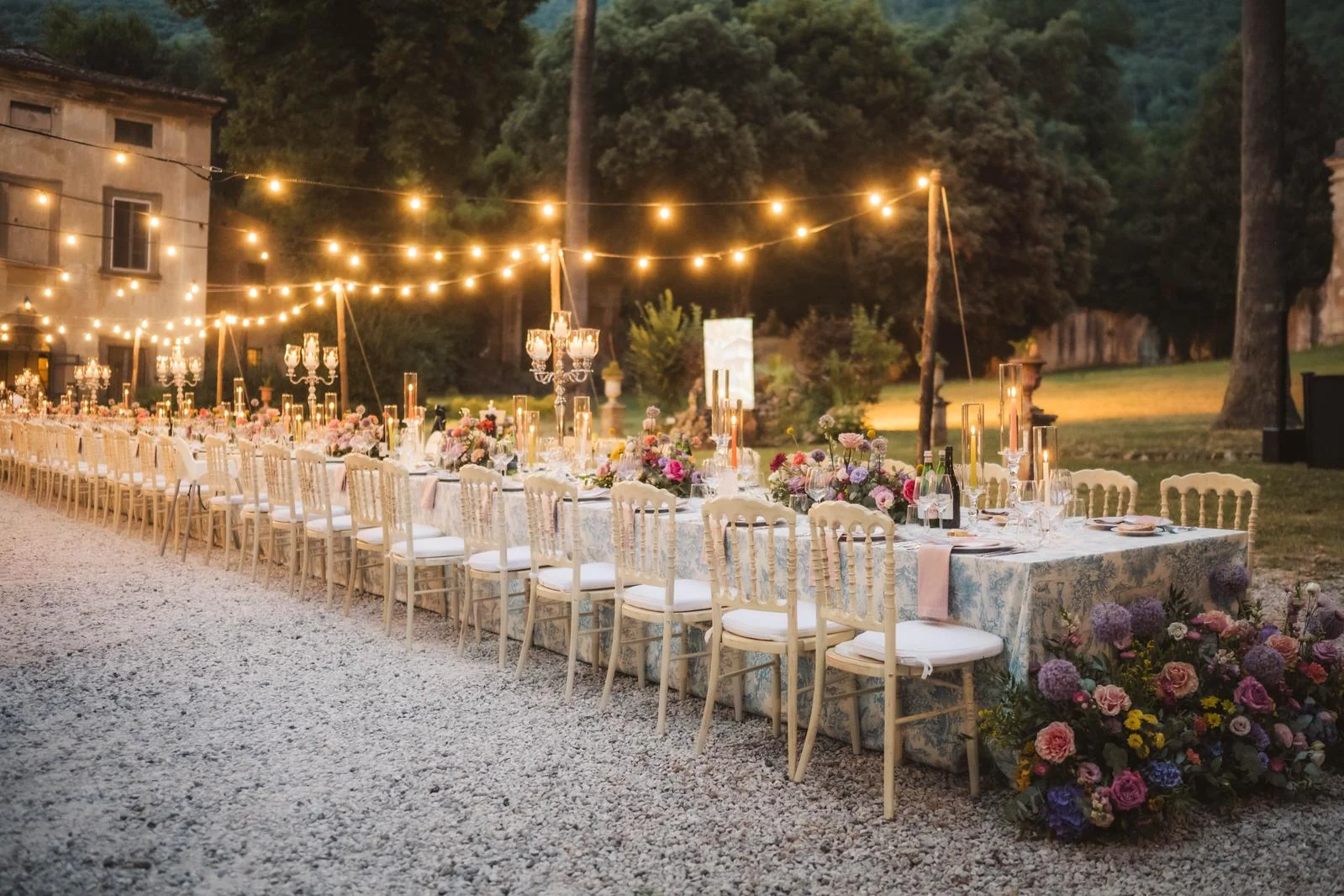 Tavola allestita in giardino con festoni luminosi