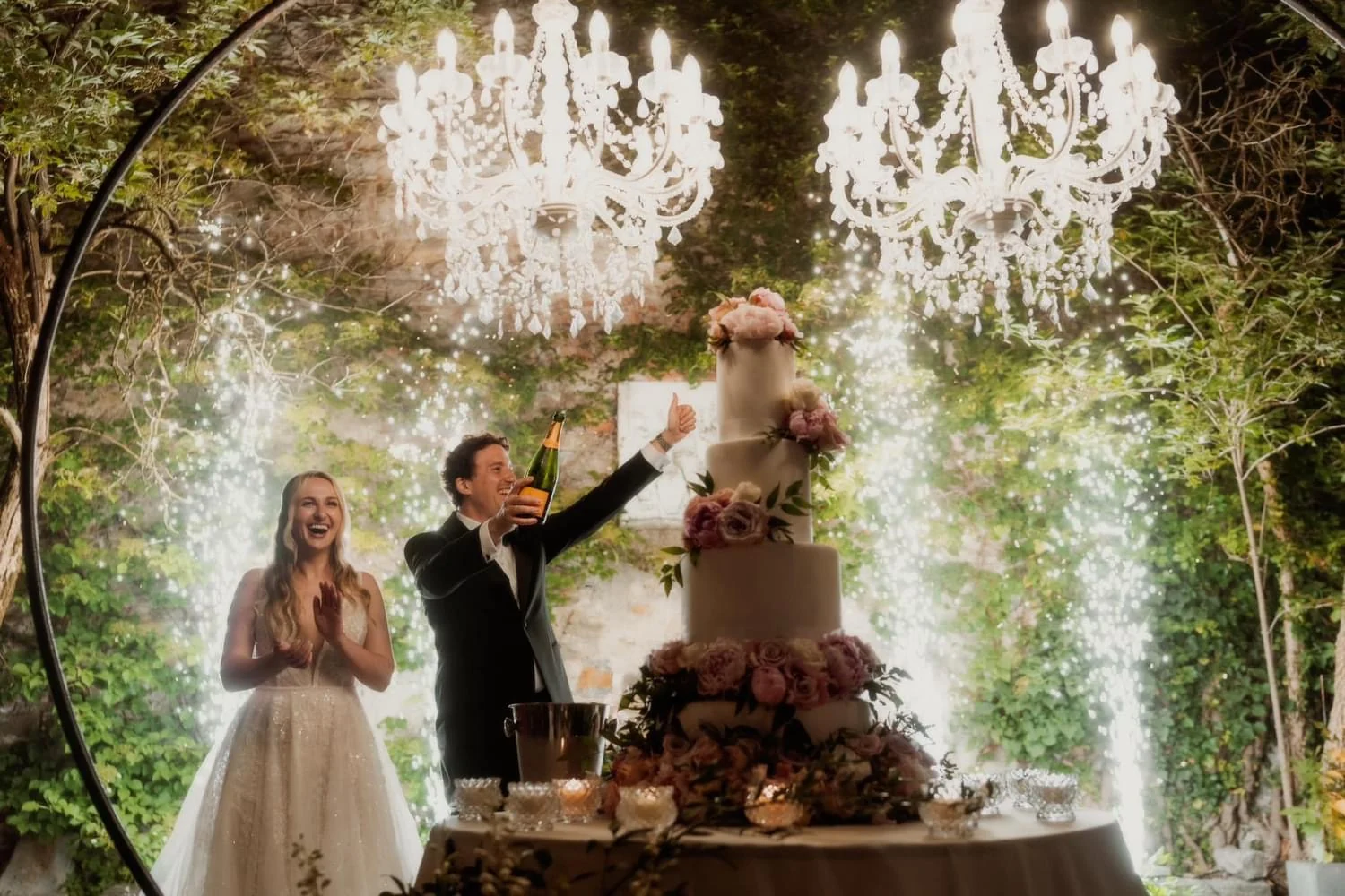 Sposi al taglio della torta con lampadari e fontane luminose
